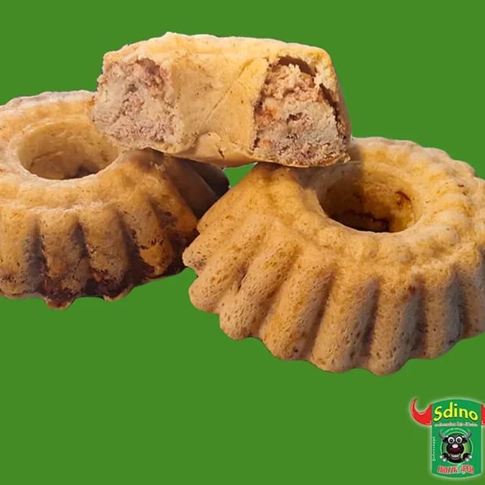 Tre babà rustici a forma di corona, uno tagliato a metà, su fondo verde
