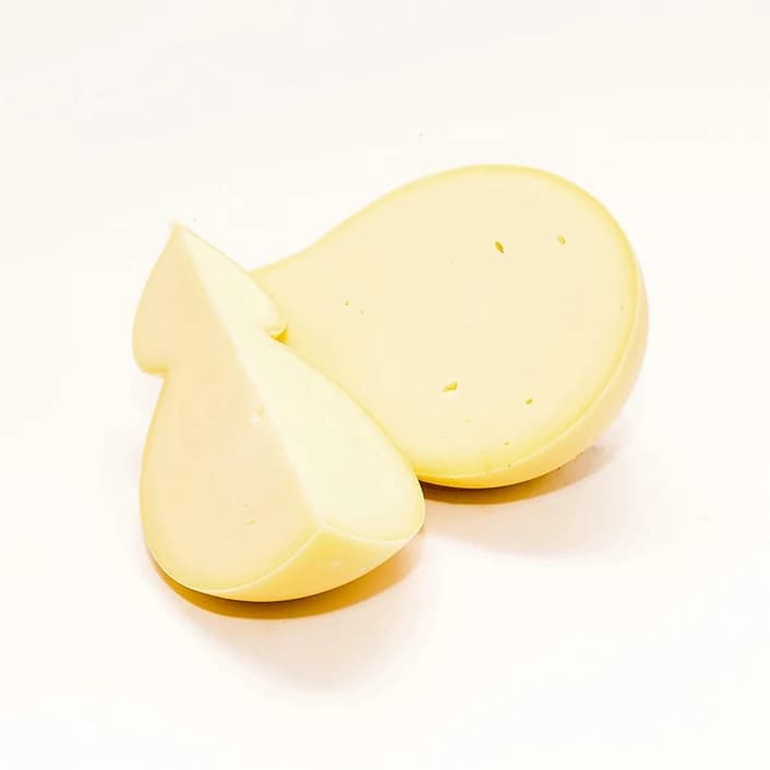 Un caciocavallo fresco tagliato a metà, dalla pasta chiara
