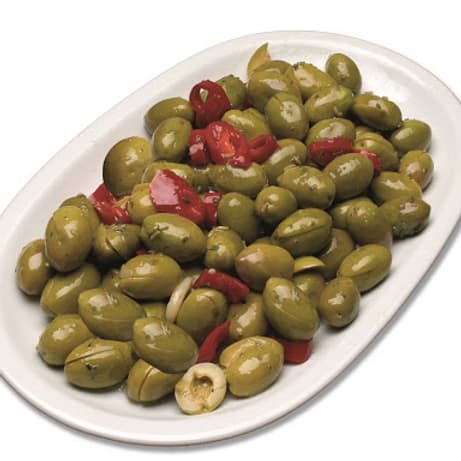 Un piatto di olive verdi condite con peperoni
