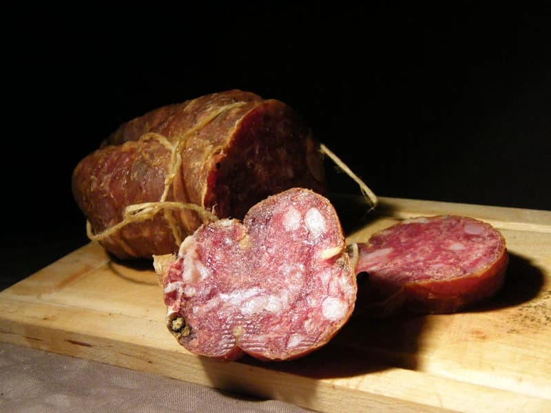 Un salame paesano tagliato a fette su un tagliere